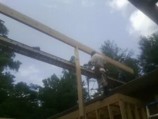 Carpenter setting a ridge beam over a new addition frame — Ice Dam Removal by Roofing Brothers in Talbotton